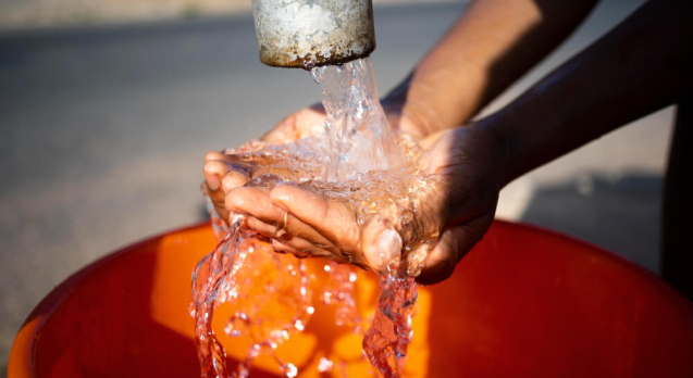 african-woman-pouring-water-recipient-outdoors (1)